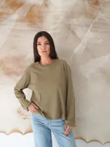 Remera negra de manga larga con cuello redondo. Jeans de tiro alto color celeste con cinturón con hebilla dorada. 