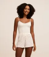 Blusa de pijama blanca de bretel fino con encaje en el escote y textura acanalada.