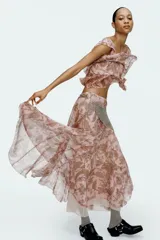 Top corto de bambula color rosa con estampado paisley en tonos dorados. Tiene escote recto, tirantes finos con volantes y cierre en la espalda con botones forrados.