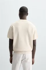 Camiseta negra de corte recto y manga corta, tejida en punto perlado de algodón.