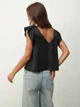Blusa negra de satén con escote en V y detalle de encaje en el escote.