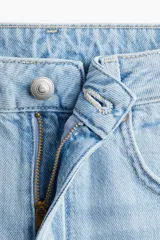 Jean celeste de denim rígido de algodón con cinco bolsillos, corte wide leg, cintura extra alta, cierre con botón y largo levemente largo. Inspirado en los 70.