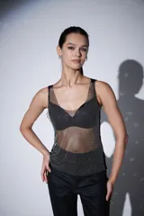 Musculosa sin mangas de poliéster con strass, corte al cuerpo y cuello profundo.