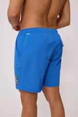 Short de baño color lila con cordón ajustable en la cintura y parche con logo de la marca en la pierna.