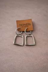 Aros colgantes plateados con forma de estribo, con cierre de gancho.