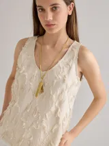 Musculosa color crudo con textura, escote en V y corte holgado.