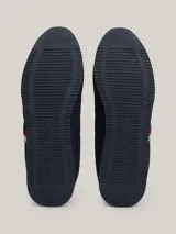 Zapatillas Tommy Hilfiger de estilo running, color azul marino con detalles en blanco y rojo. Confeccionadas en poliuretano y poliéster, con suela de EVA y logo de la marca en el lateral y el talón.