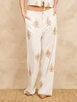 Pantalón de lino color crudo con bordados dorados, corte palazzo y cintura alta.