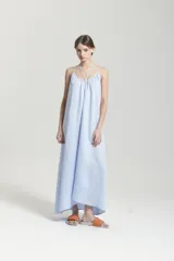 Vestido largo de lino color celeste, con breteles finos y diseño amplio con vuelo en el ruedo.