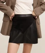 Minifalda negra de cuero con paneles geométricos de gamuza.