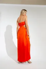 Vestido largo de fiesta color naranja, de un solo hombro, con abertura en la falda y corte en la cintura.
