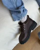 Borcego marrón de cuero con cordones, caña baja y suela track.