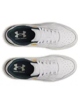 Zapatillas deportivas Under Armour modelo Flex, color blanco con detalles en verde oscuro y amarillo mostaza. Presentan una silueta inspirada en el estilo de baloncesto retro, con parte superior de cuero y suela de goma color caramelo.