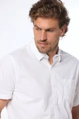 Camisa azul marino lisa de manga corta con cuello abotonado, cierre frontal con botones y bolsillo en el pecho. Confeccionada en algodón.