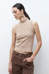 Top sin mangas color tostado melange, de tejido acanalado y cuello alto.