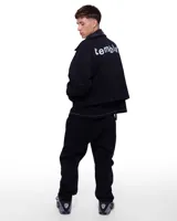 Campera bomber de jean azul con cuello de cuero negro y puños de algodón.