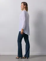 Blusa blanca de manga larga con cuello a la base y escote en V con botones. Terminación de manga con elástico.
