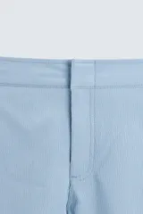 Short de baño celeste de tejido técnico con cintura elástica ajustable con cordón interior y trabillas laterales. Tiene bolsillos frontales y bolsillo trasero con cierre de cremallera. Cuenta con forro interior y cierre frontal con cremallera y botón a presión oculto.