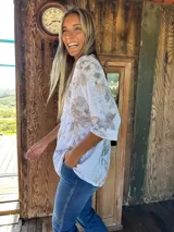 Blusa blanca estampada con flores grises y rosas, cuello mao y cartera de tres botones.