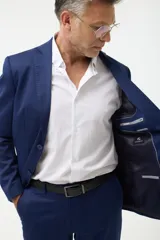 Ambo azul marino de corte clásico, compuesto por saco de dos botones con solapa de muesca, bolsillo de pecho y dos bolsillos delanteros con solapa, y pantalón de vestir con pinzas y bolsillos laterales y traseros.