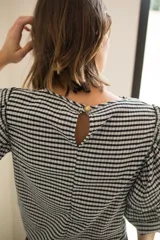 Blusa con spandex con estampado vichy blanco y negro, mangas al codo con tres volados y puño elástico. Cierre con botón en la espalda.