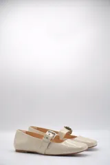 Chatitas tipo Mary Jane de charol negro con punta redondeada y tira sobre el empeine con hebilla metálica plateada.