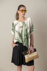 Blusa italiana color natural con estampado de hojas en tonos azules. De calce holgado y talle único.