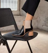 Bota corta de cuero vacuno color negro, con elástico lateral, taco de madera y punta fina.