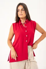 Camisa roja sin mangas con cuello mao adornado con un volado y cierre frontal con botones.
