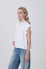 Blusa de viscosa color celeste, con cuello a la base, frunces y punto smock en el pecho y los hombros, y mangas cortas con volados.