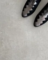 Botín de cuero vacuno color bronce con puntera y caña en cuero negro. Diseño con borde superior en zigzag y taco de madera.