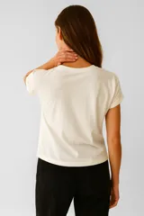 Remera verde militar de algodón con estampado de flores y texto en color crema.