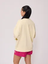 Sweater color crema con estampado frontal de motivos playeros y bordado. Confeccionado en 60% algodón y 40% poliéster.