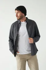 Camisa de hombre color marrón con efecto stone wash, fit regular, cuello americano, cierre con botones, dos bolsillos frontales con botón y mangas largas con puños abotonados.