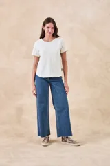 Remera blanca de manga corta con cuello redondo y bordados florales monocromáticos en relieve.