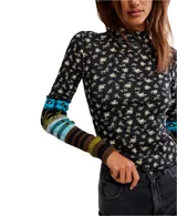 Top de manga larga ajustado, color negro con estampado floral pequeño en tonos beige y amarillo. Presenta cuello alto tipo mock con borde festoneado y puños alargados de punto con diseño multicolor a rayas y patrones geométricos en tonos azul, verde, marrón y negro.