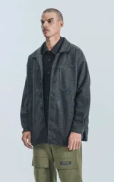 Chaqueta gris de paño con cuello clásico, cierre frontal con botones, bolsillos laterales y corte recto.