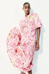 Vestido largo de algodón color rosa con estampado floral, cuello mao, mangas globo cortas, cinturón fino extraíble y falda acampanada con fruncido escalonado.