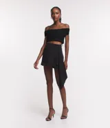 Short pollera corto color negro, confeccionado en crepé con cierre en la espalda y cinta lateral.