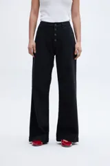 Pantalón jean negro de corte holgado con pierna ancha y tiro medio. Cierre frontal con botones a la vista.