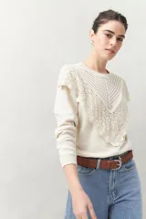 Sweater color crema de punto liso con detalle de crochet en el escote y en forma de pico sobre el pecho.