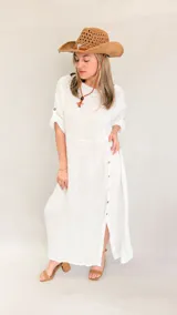 Vestido largo oversize de lino color blanco, con mangas 3/4 con botón y abertura lateral con botones.
