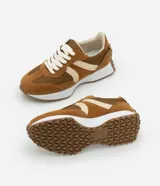 Championes de estilo jogging para mujer, confeccionados en poliuretano color tostado con recortes contrastantes en color crema. Presentan cierre de cordones blancos y suela de PVC que se extiende hasta el talón con base dentada.