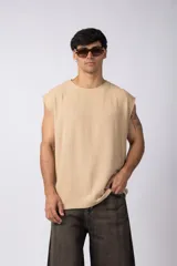 Musculosa color beige tejida en lino con textura marcada, corte suelto, sin mangas, terminaciones deshilachadas y costura central en la espalda.