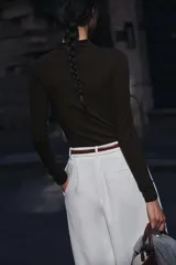 Camiseta blanca de manga larga con cuello alto y corte ajustado.