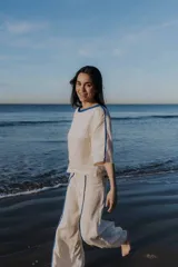 Blusa color crudo de lino natural, corte holgado, con cuello redondo y mangas 3/4 con ribete azul.