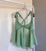 Top verde agua con escote halter, abertura central y detalles de lentejuelas y bordados en el corpiño.