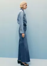 Pantalón de jean azul de tiro alto, corte wide leg, con bolsillos delanteros y traseros, cierre con cremallera y botón.