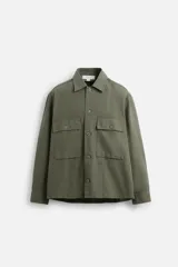 Sobrecamisa verde militar de algodón con estructura canvas, corte relaxed fit, cuello solapa, manga larga con puños abotonados, bolsillos frontales de plastrón con solapa, efecto lavado y cierre frontal con botones.