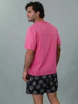 Conjunto de pijama Calvin Klein de dos piezas. Incluye una remera rosa de manga corta con cuello redondo y logo estampado en el pecho, y un short negro con estampado de corazones y logo de la marca.